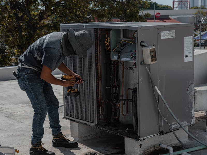 Expert HVAC technician installing rooftop air conditioning equipment