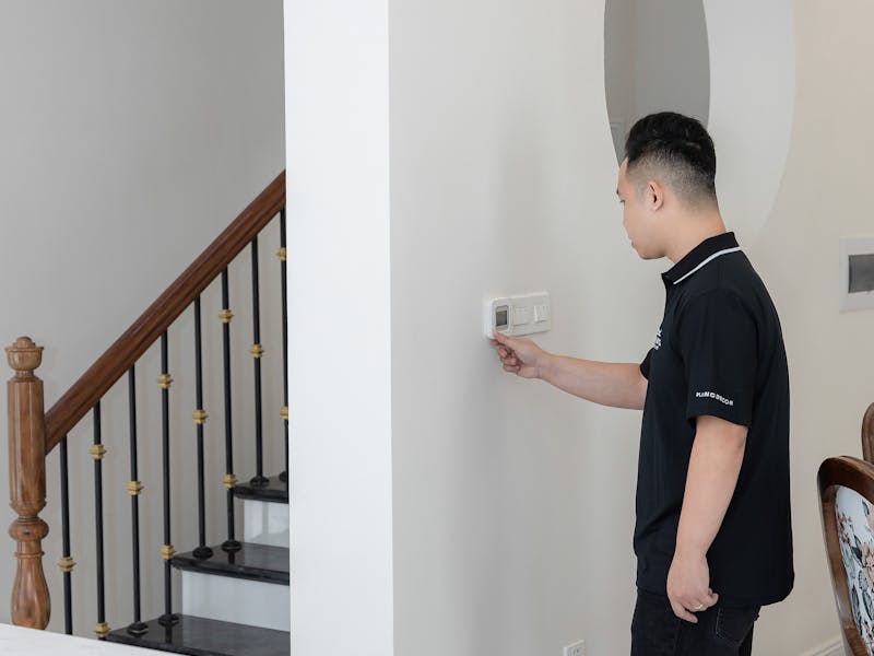 Homeowner adjusting thermostat for optimal heating comfort and energy savings