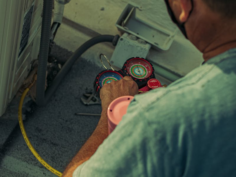 Certified technician repairing outdoor heating and cooling equipment